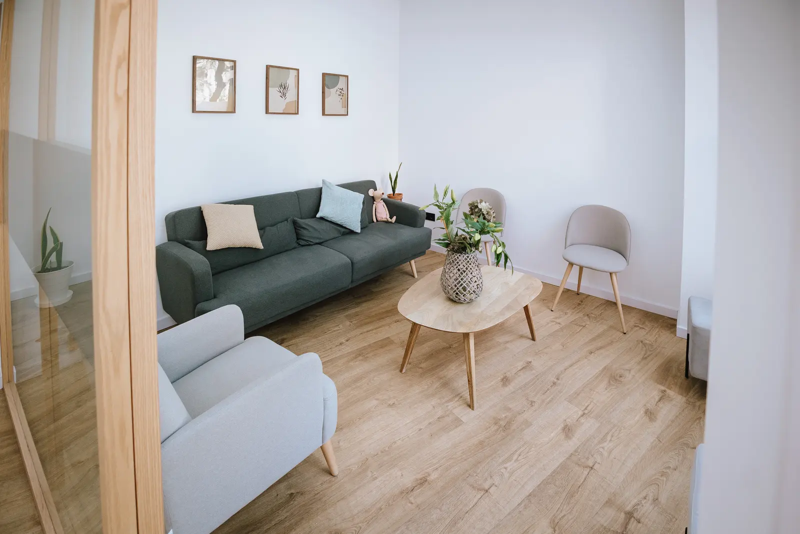 Sala de espera de Clínica Balbea con sofá verde y sillones