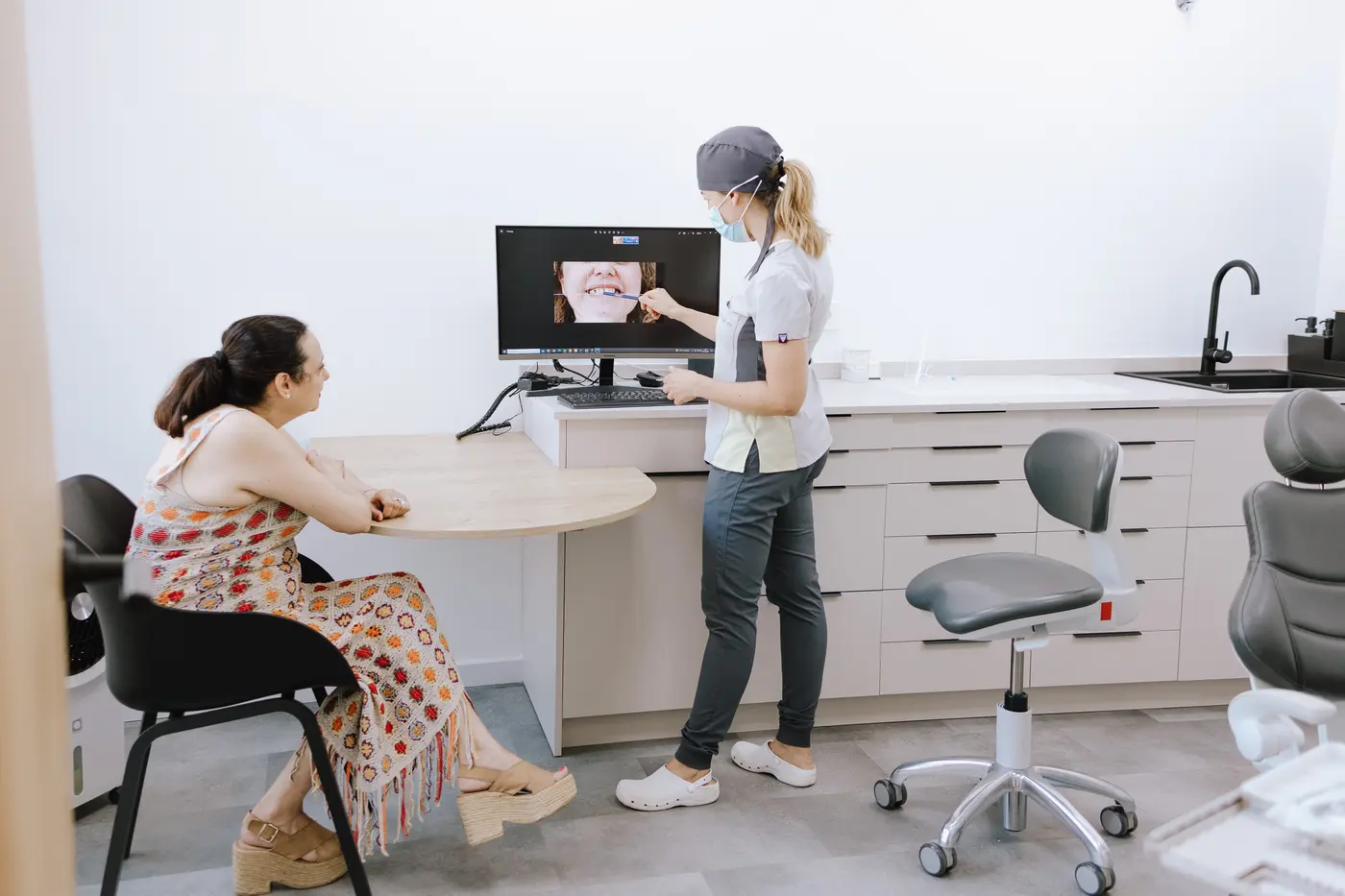Doctora explicando a una paciente su diagnóstico en pantalla durante la consulta