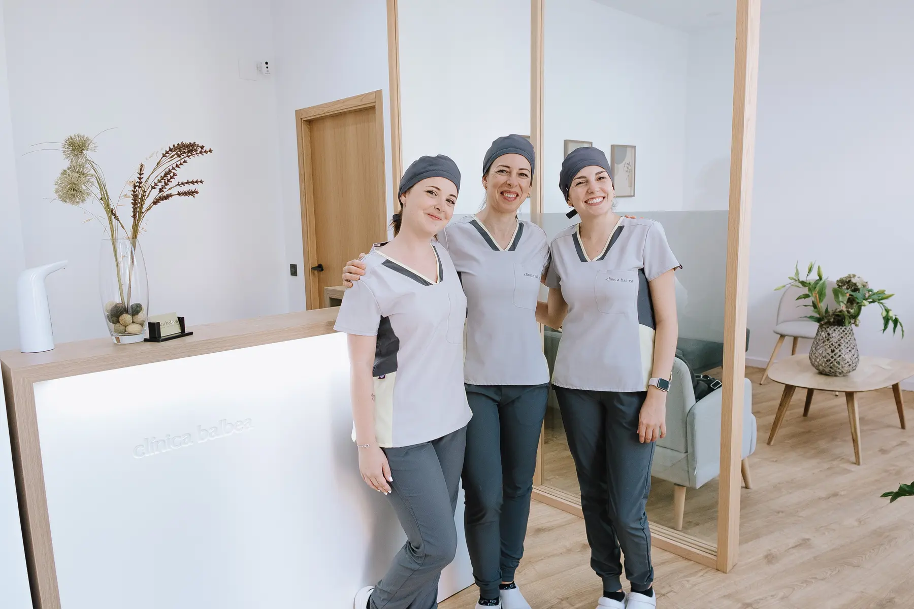Equipo de Clínica Balbea sonriendo junto al mostrador de recepción