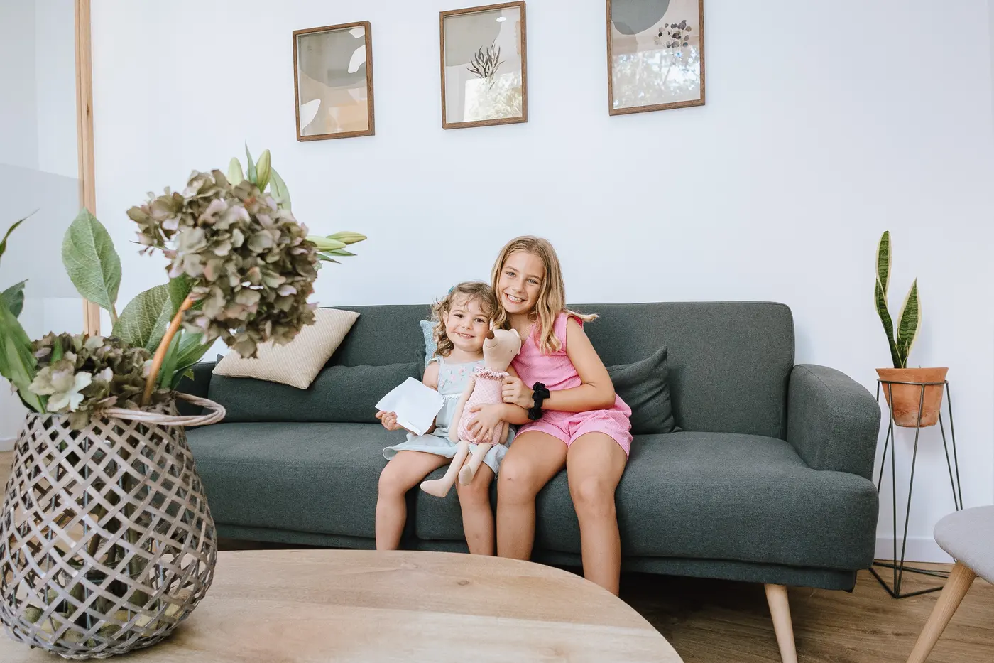 Dos hermanas sonriendo en la sala de espera infantil de Clínica Balbea